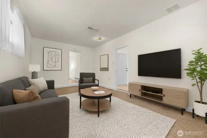 Family room with no furniture, located at NW corner of home with access to carport.