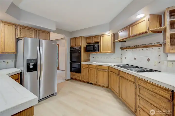 Additional kitchen features include a full-size double wall oven, down-draft cooktop and microwave nook.