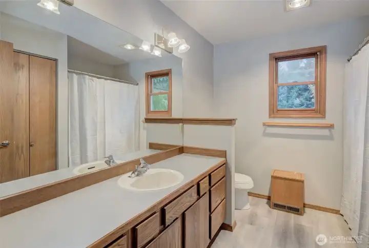 Main bathroom offers new LVP floor, laundry chute and plenty of space to upgrade to a dual vanity!