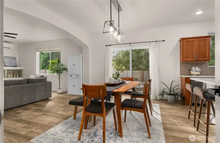 The dining room features a stunning arched opening that seamlessly connects to the kitchen and living room, creating a spacious and inviting atmosphere.
