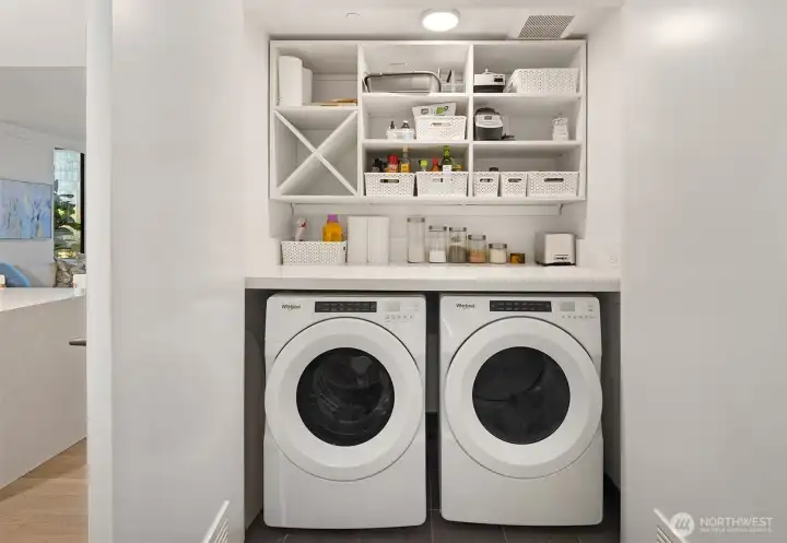 Laundry room with custom storage space above.