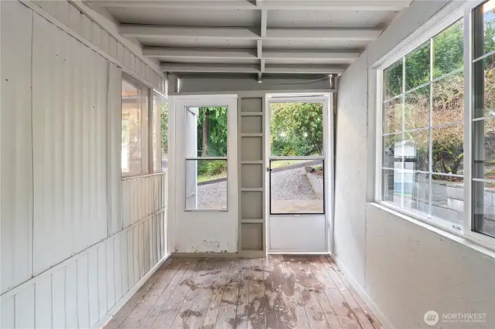 Versatile enclosed porch area suitable for hobbies, storage, or relaxing. Versatile enclosed porch area suitable for hobbies, storage, or relaxing.