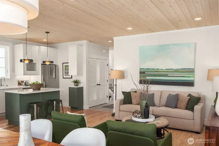 The large living room, dining room and kitchen is warmed by custom pine paneled ceilings.