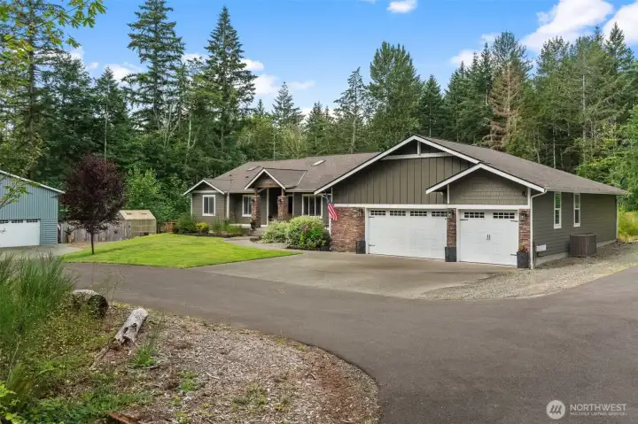 Privately situated behind a gated entrance, this well-maintained home is surrounded by lush landscaping and a picturesque wooded backdrop.