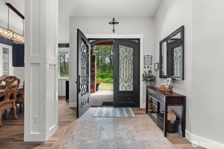 Elegant double doors open to a spacious foyer with soaring ceilings, creating a warm and welcoming introduction to the home.