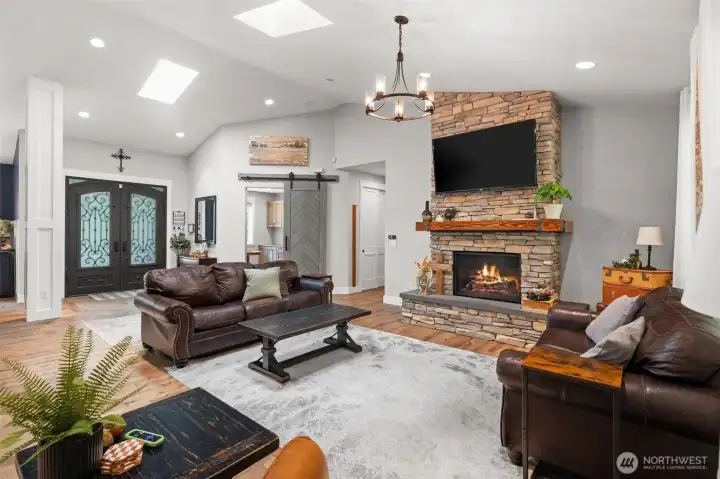 Spacious great room with a floor-to-ceiling stone fireplace and an open layout that connects seamlessly to the surrounding living areas.