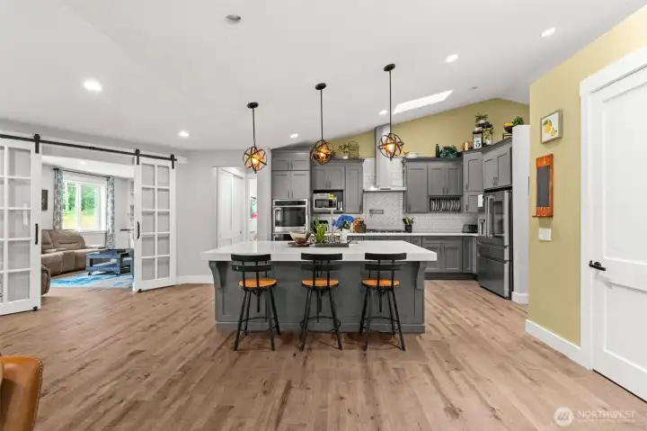 A large island anchors the kitchen, offering additional prep space, casual seating, and easy access to the surrounding living areas.