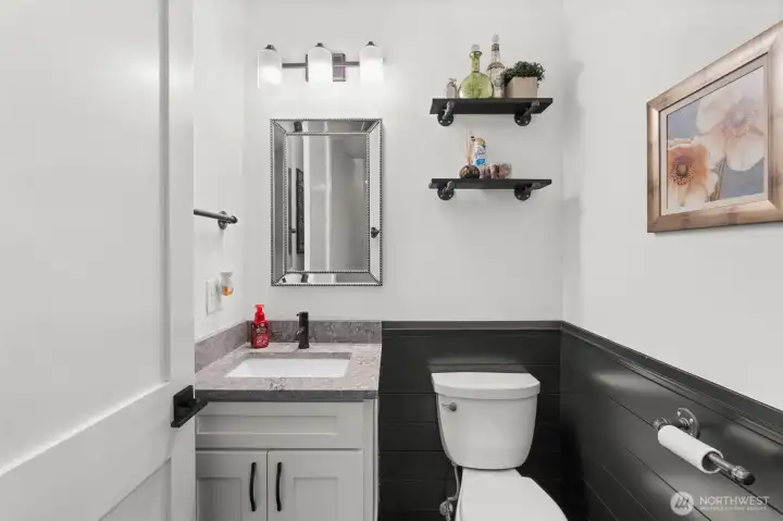 Powder room features a single-sink vanity, updated fixtures, and decorative shelving.