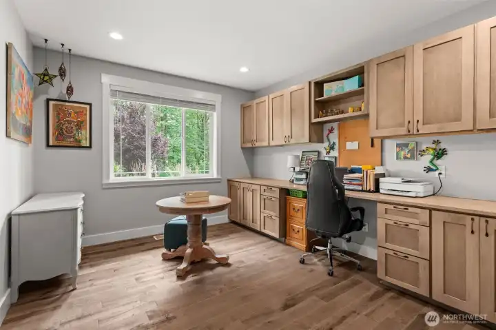 Dedicated office with custom built-in cabinetry, generous workspace, and abundant storage offers a functional setting for working from home, studying, or creative projects.