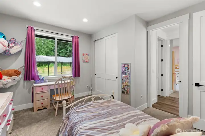 Comfortable bedroom with a spacious closet, natural illumination, and a functional layout.
