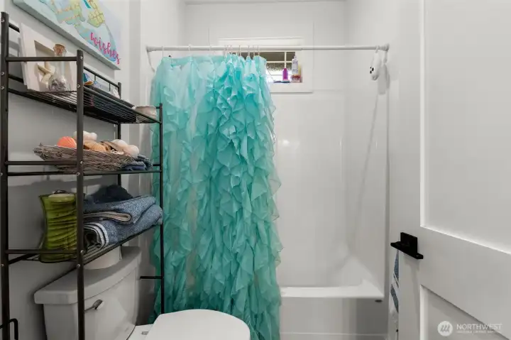 Well-appointed full jack/jill bathroom features a tub/shower combination and functional storage for everyday essentials.