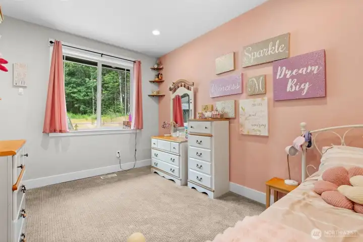Additional bedroom provides a functional layout with a large closet and window bringing in views of the surrounding greenery.