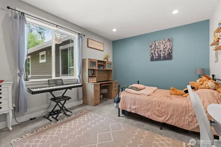 Spacious bedroom features a large window, soft carpeting, and flexible space to accommodate a variety of lifestyle needs.