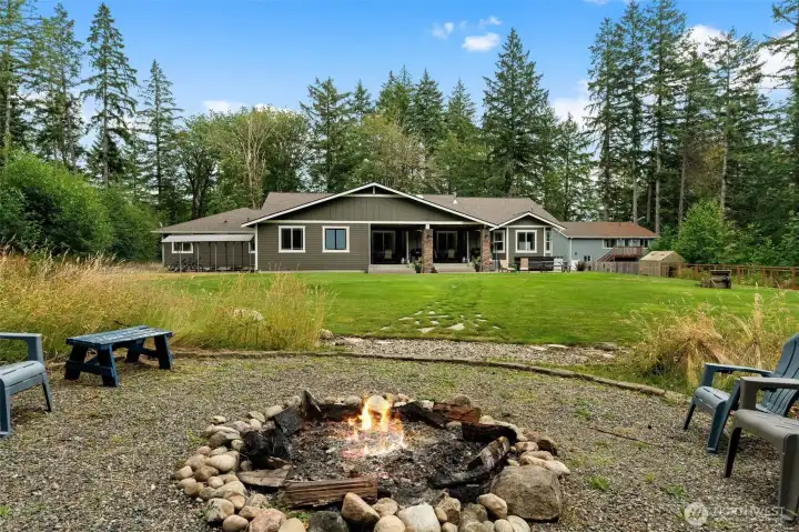 Level backyard provides room for recreation, a storage shed, and an established fire pit area for outdoor enjoyment.
