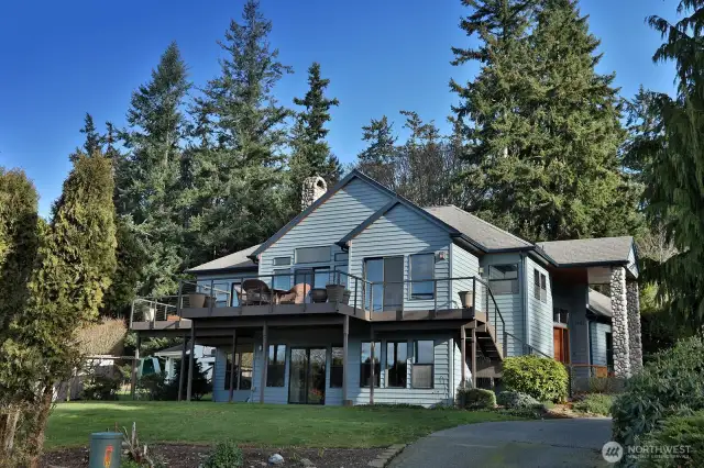Located at the end of the lane, this is the view driving up to your home. The newer composite deck expands the entire length of the view side of your home. Exterior stairs lead from the deck to your yard.