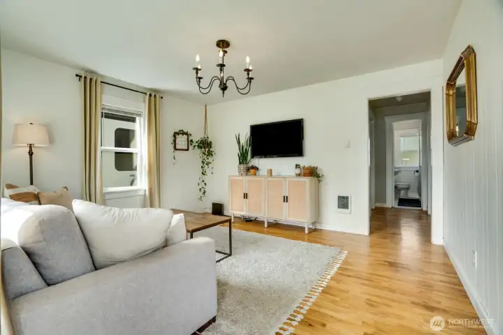 Enter into the main living room. Beautiful and well kept hardwood floors, modernized windows, light fixtures and systems.