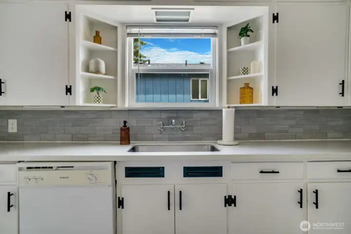 Undercount sink, timeless wall mounted faucet, open shelving and many cabinets for your kitchen gadgets
