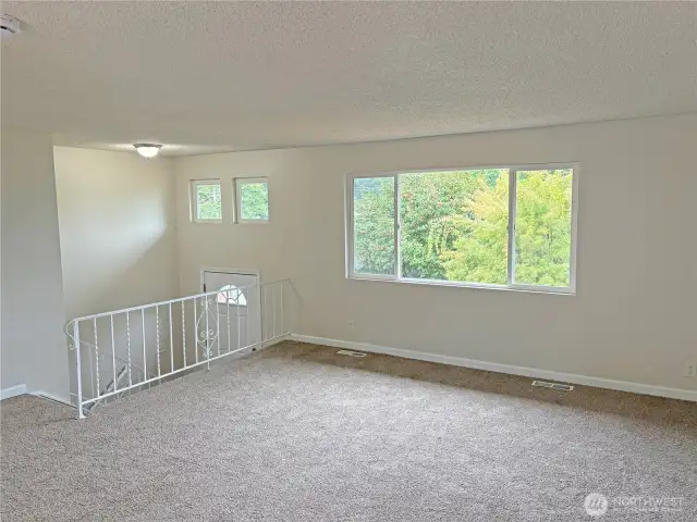 Living room with fresh paint and new flooring in an updated split-level home on a quiet cul-de-sac in Cascade, Renton WA 98058.