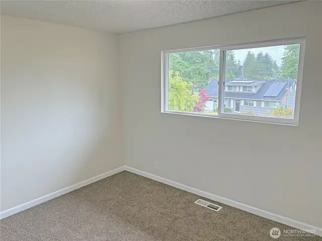 Bedroom #2 in the updated split-level at 16312 127th Pl SE, Renton—fresh paint, new flooring, and closet storage; comfortable secondary bedroom in the Cascade neighborhood 98058.