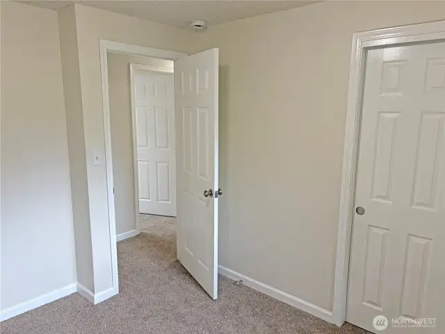 Bedroom #3 in the updated split-level at 16312 127th Pl SE, Renton—bright secondary bedroom with new flooring, fresh paint, and closet storage; situated in the Cascade neighborhood 98058.