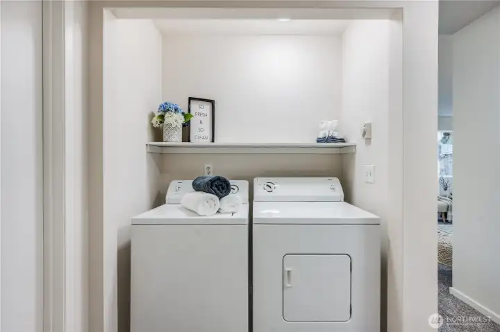 An in-unit washer and dryer stay with the home, tucked into this closet in the hallway.