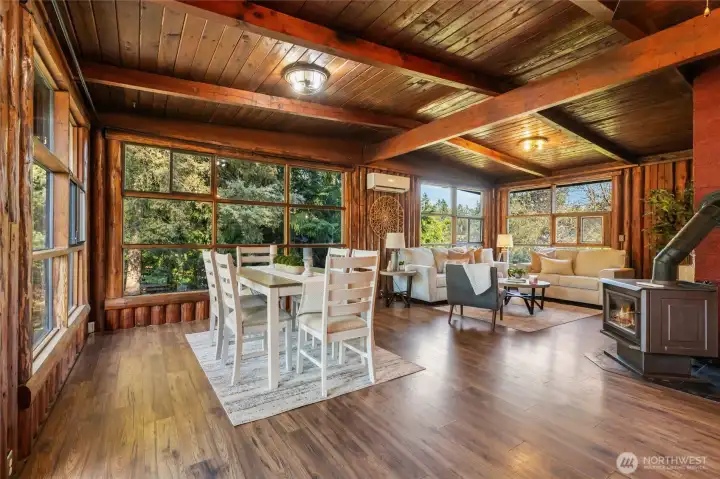 Open concept kitchen, dining and living room with floor to ceiling windows and vaulted ceilings