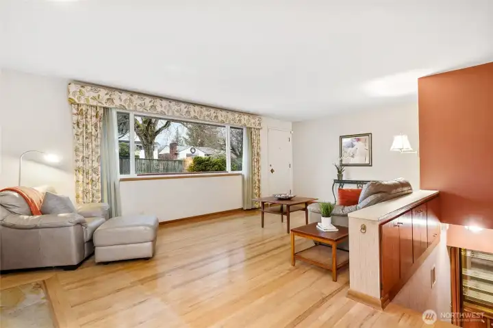 Comfortable living room with hardwoods, wood burning fireplace and built-ins above the stairs.