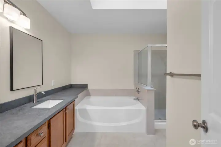 Private en-suite bathroom with a soaking tub and separate shower.