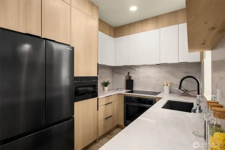 Gourmet kitchen boasting sleek black cabinetry, high-end appliances, and ample prep space.