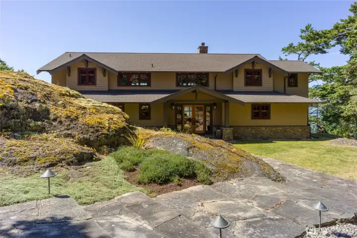 Wide stone path leads to this private, well crafted home.