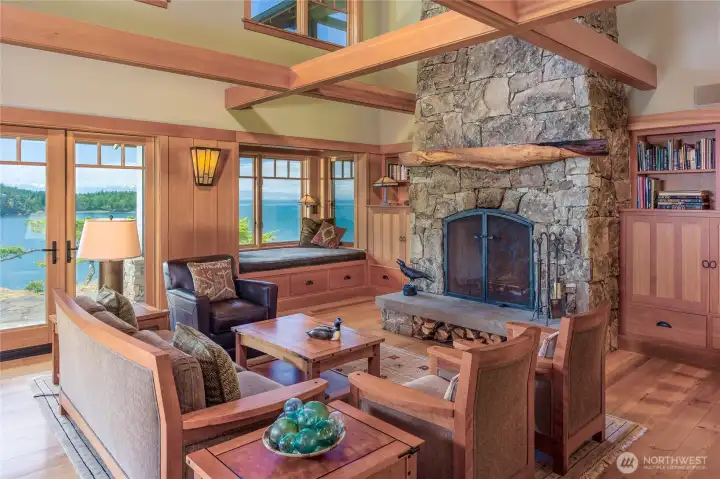 Great room with stone fireplace with extra large fire box, built-in daybed and cabinets. French doors to sunny patio.