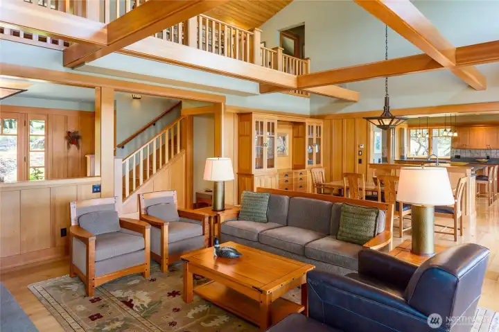 Another view of the great room with entry to left looking toward the kitchen. Balcony above connects 2 bedrooms.