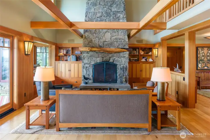 The stone fireplace with madrona mantel and built-in media and TV cabinets on each side.