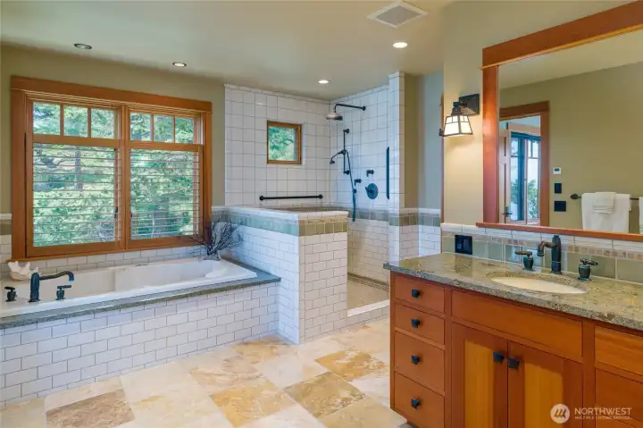 Main floor primary bathroom includes jetted tub and spacious shower.