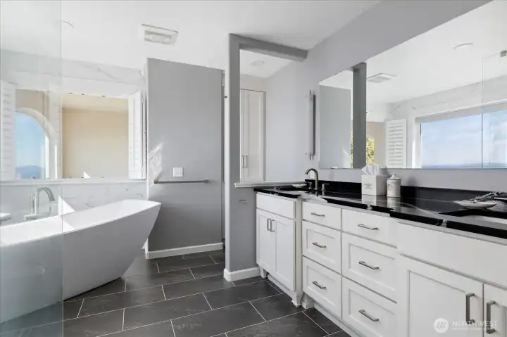 Primary Bath is adjacent to the Primary bedroom with dual sink vanity & quartz countertops, vinyl plank flooring, and a Toto bidet toilet.