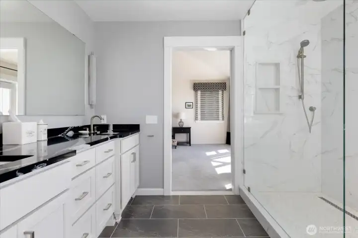 The Primary Bath has a walk-in stall shower with marble walls and pebble rock floor.