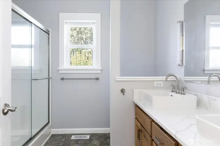 Next to the 2nd level Guest Room (bedroom #2) is a 3/4 bath with dual sink vanity and quartz countertop, large stall shower with double sliding glass doors, linen closet and vinyl flooring.