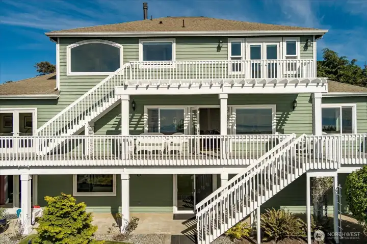 This view of the home shows the back side that faces the Sound & Mountains, and the intricate layout of the multi-level deck system.
