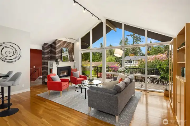 Sunlit living room with a vaulted ceiling and a wall of windows that illuminate the interior with natural light