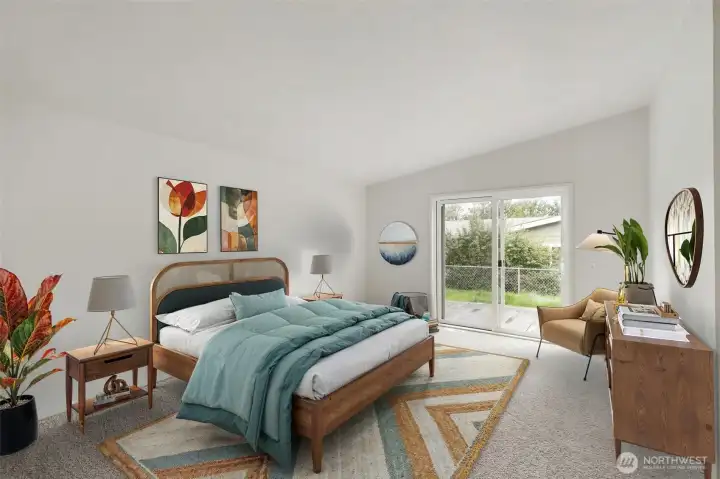 Virtually staged primary bedroom w/ vaulted ceilings and access to the back yard.