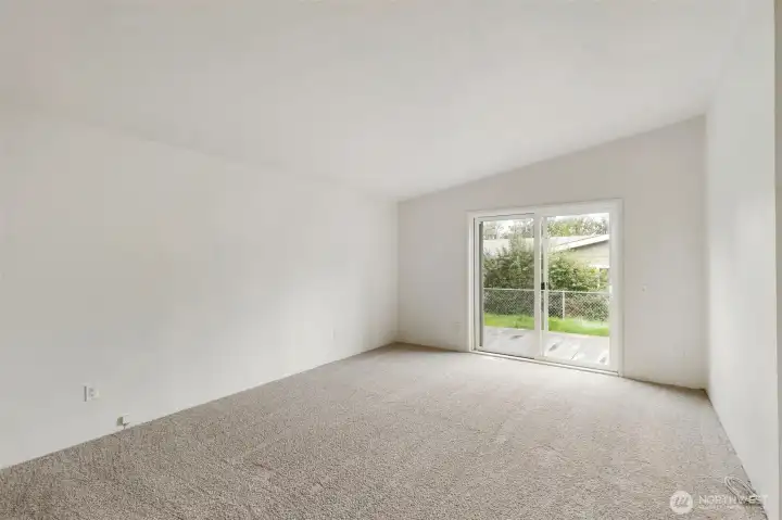Primary bedroom w/ vaulted ceilings  and access to the back yard.