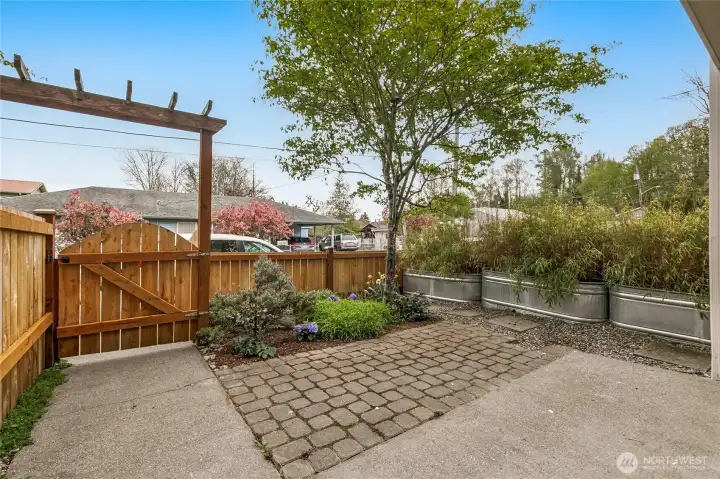 Fenced front yard with space for gardening, BBQ, lounging, visiting.