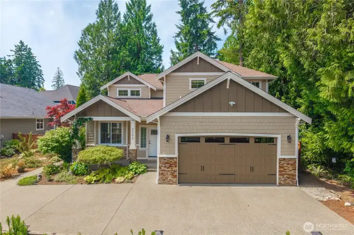 Enjoy your morning coffee on the covered front porch while listening to bird song and smelling the climbing roses. The porch is a private spot, shielded from view by grown-in cottage-type landscaping. Appreciate the custom architectural facade details like brick veneer, shingle siding and craftsman-style pillars.