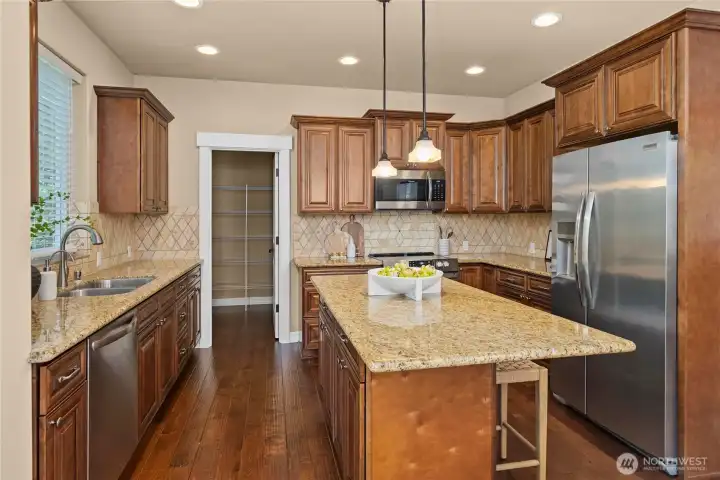 The kitchen island is great for baking projects or sitting down for breakfast. It features a spacious walk-in pantry, granite counters, instant hot water, and stainless steel appliances.