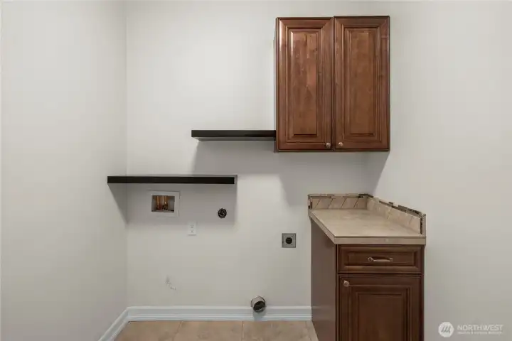 The main-floor laundry room is appointed with storage cabinets, shelves and a small folding counter.