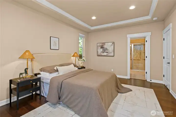 The room is appointed with a tray ceiling and elegant white millwork.