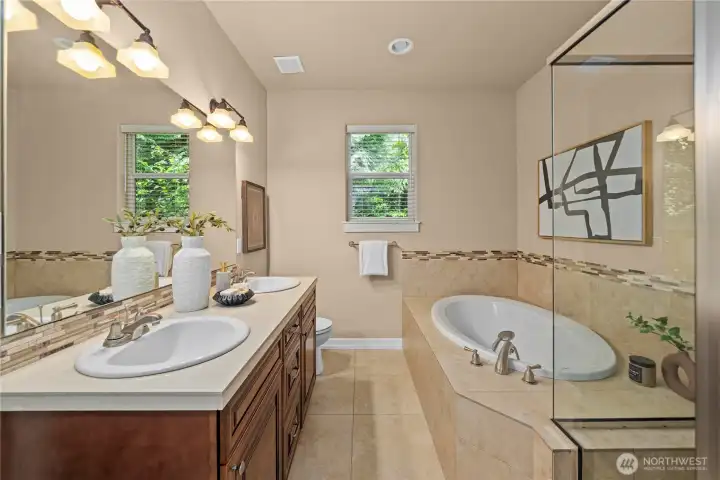 The main-floor primary bathroom features a dual-sink vanity, deep soaking tub and large-walk-in shower.