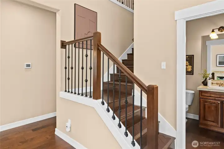 The wood staircase features beautiful wrought-iron railing and cozy, non-slip carpet stair treads.