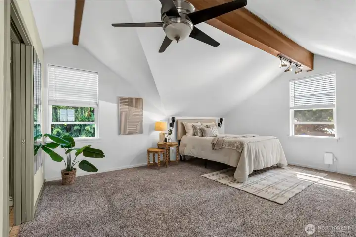 Spacious primary suite with vaulted ceilings, exposed beam detail, and abundant natural light for a comfortable retreat. Spacious primary suite with vaulted ceilings, exposed beam detail, and abundant natural light for a comfortable retreat.