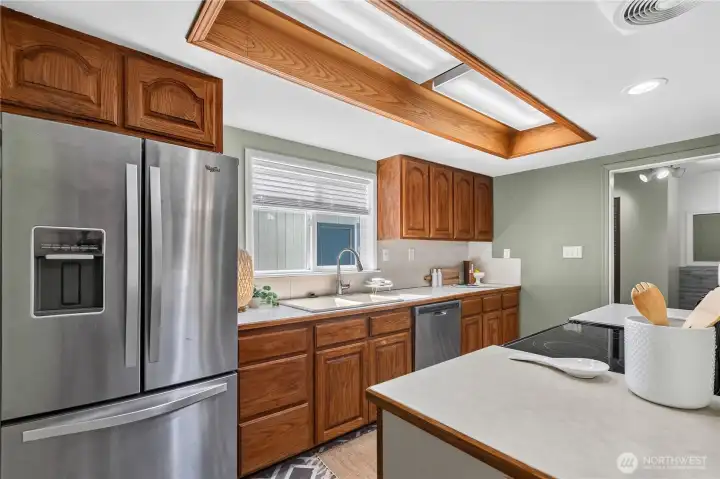 Functional kitchen offers abundant cabinetry, generous counter space, stainless steel appliances, and a convenient double sink overlooking the backyard. Functional kitchen offers abundant cabinetry, generous counter space, stainless steel appliances, and a convenient double sink overlooking the backyard.